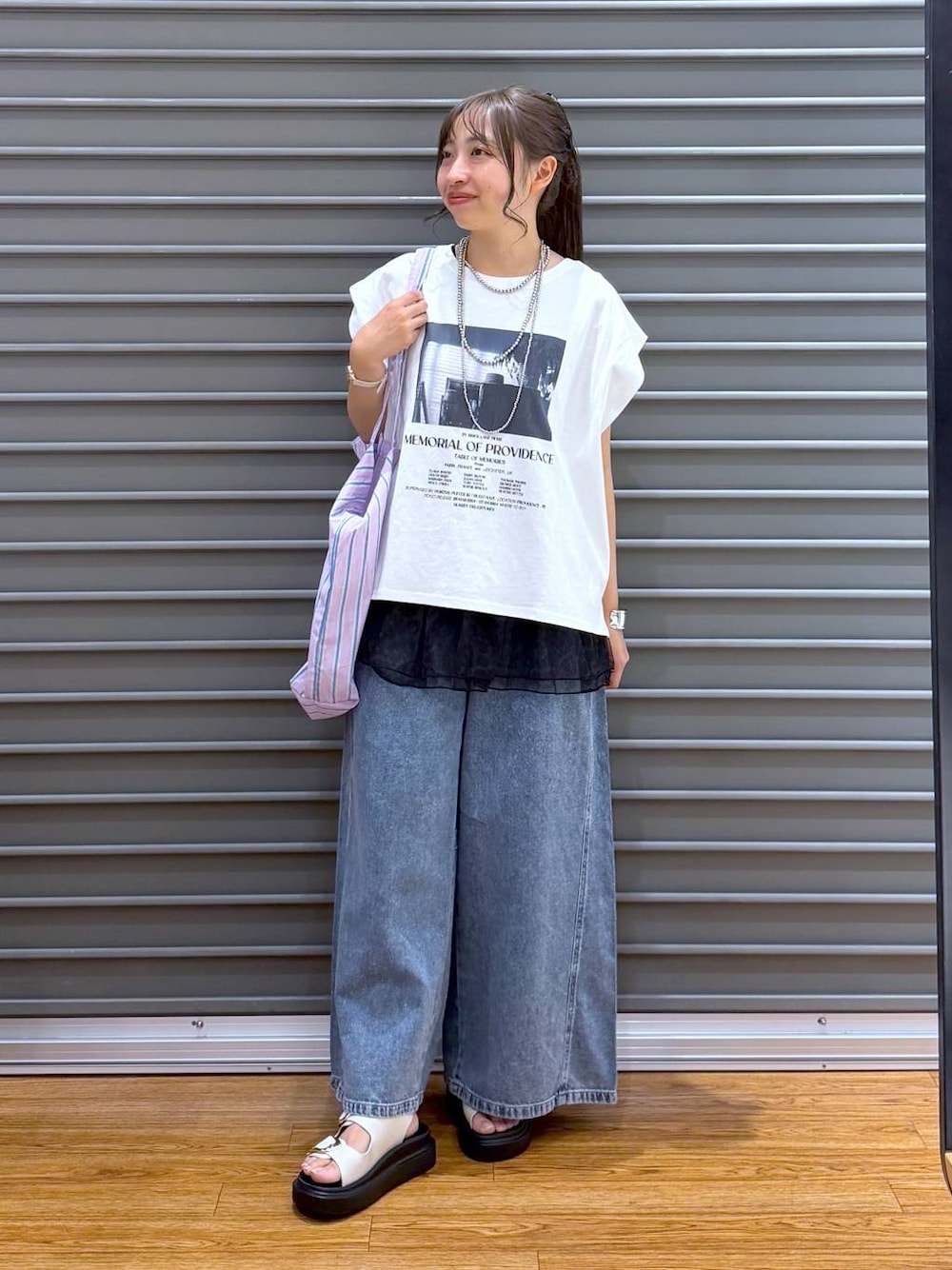 パープル系のトートバッグ、ホワイト系のサンダル、ホワイト系のTシャツ/カットソーを着用したレディースの夏コーディネートの1枚目の写真