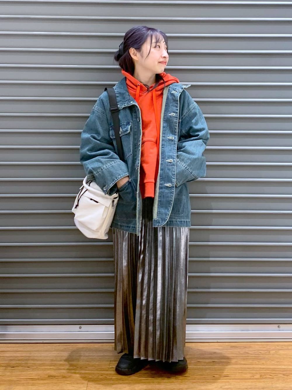 ホワイト系のショルダーバッグ、ブルー系のデニムジャケット、グレー系のスカートを着用したレディースの春コーディネートの1枚目の写真