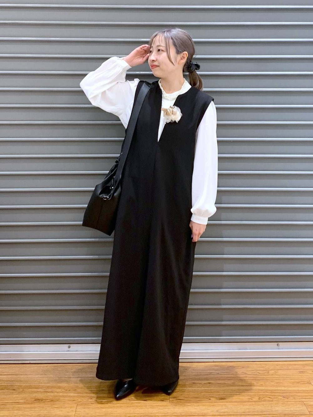 ホワイト系のシャツ/ブラウス、ブラック系のサロペット/オーバーオール、ブラック系のパンプスを着用したレディースの冬コーディネートの1枚目の写真