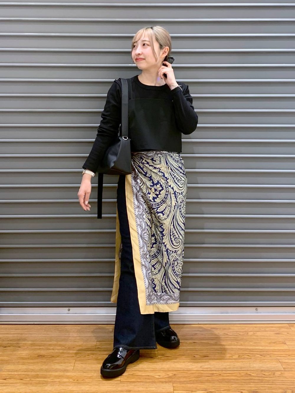 ブラック系のショルダーバッグ、ブラック系のキャミソール、ブラック系のローファーを着用したレディースの春コーディネートの1枚目の写真