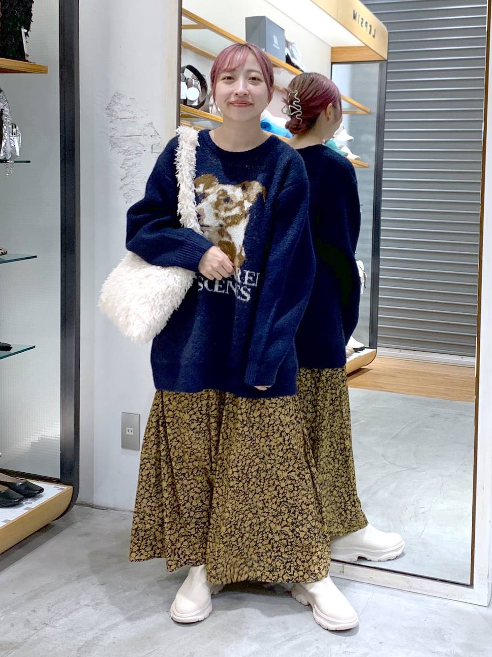 ホワイト系のショルダーバッグ、ホワイト系のブーツ、ブルー系のニット/セーターを着用したレディースの秋コーディネートの1枚目の写真