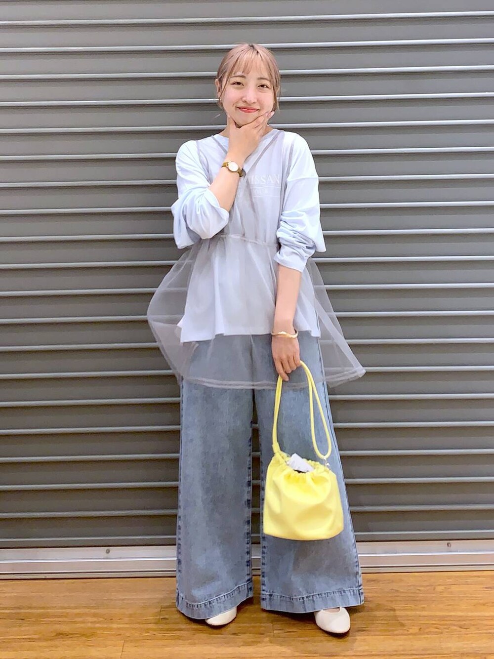 ブルー系のデニムパンツ、ホワイト系のバレエシューズ、イエロー系のショルダーバッグを着用したレディースの春コーディネートの1枚目の写真