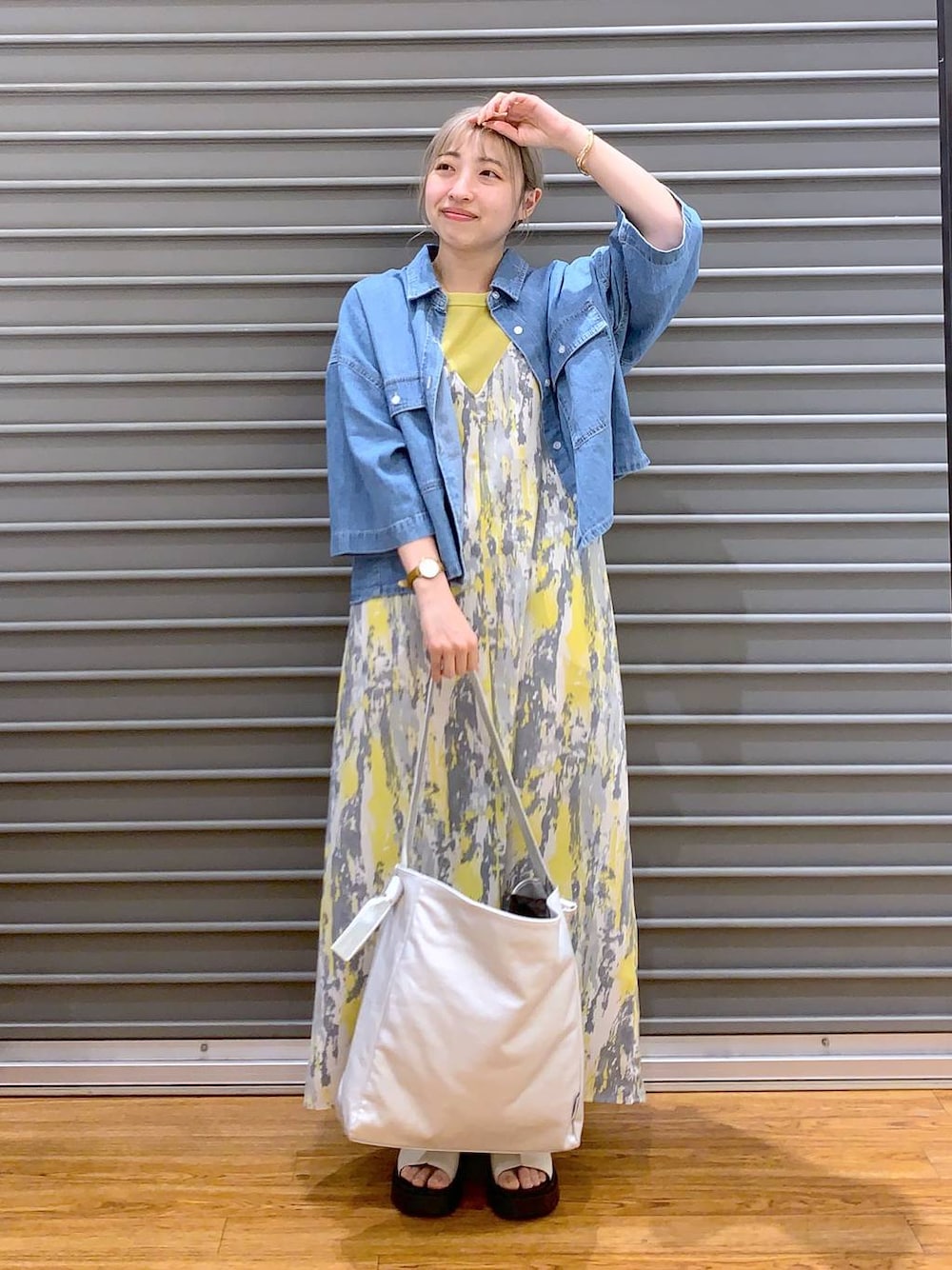 イエロー系のワンピース、ブルー系のシャツ/ブラウス、ホワイト系のサンダルを着用したレディースの夏コーディネートの1枚目の写真