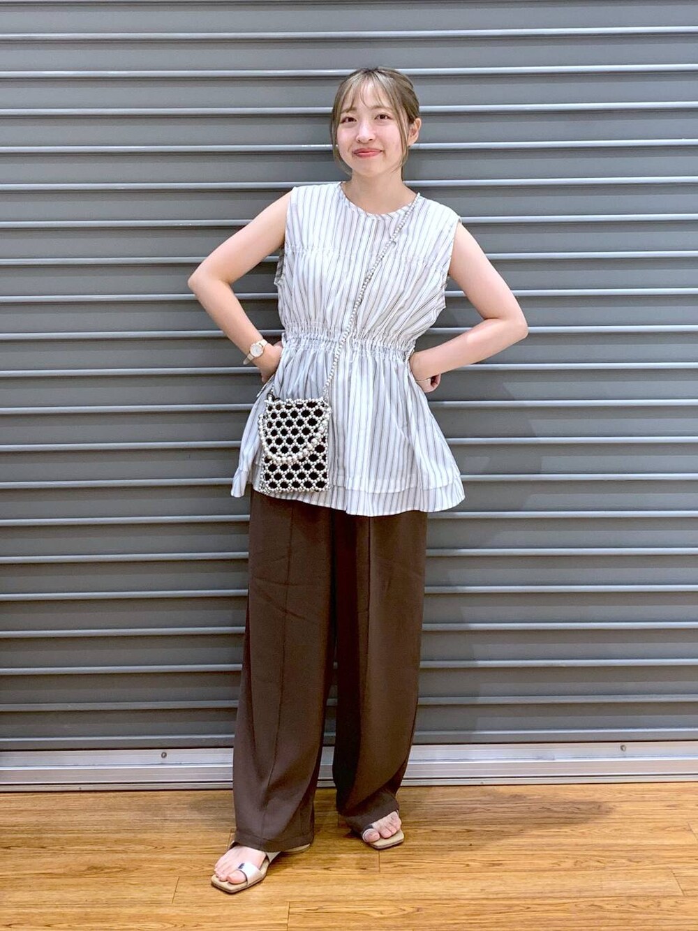 ブラウン系のその他パンツ、シルバー系のショルダーバッグ、ベージュ系のサンダルを着用したレディースの夏コーディネートの1枚目の写真