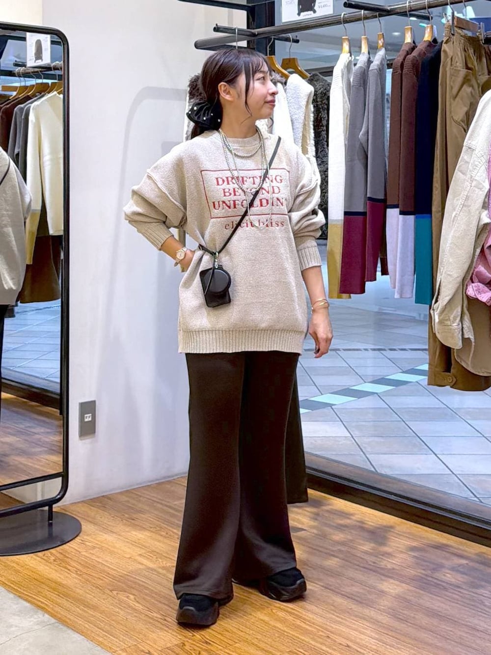 ブラック系のスニーカー、ブラック系のその他パンツ、ホワイト系のニット/セーターを着用したレディースの秋コーディネートの1枚目の写真
