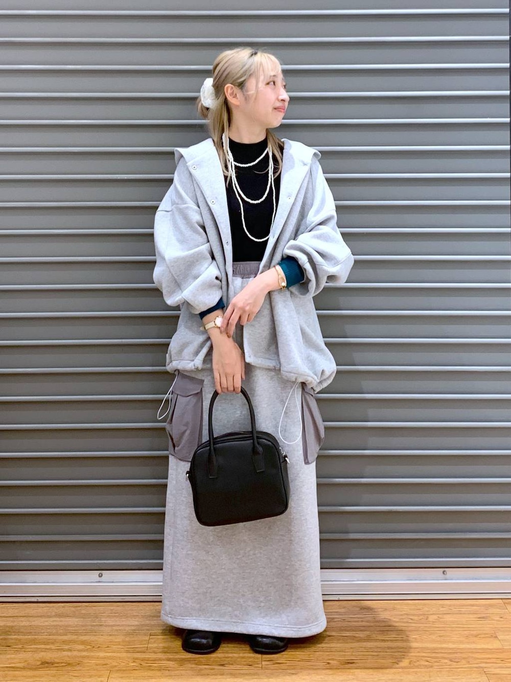 グレー系のブルゾン、ブラック系のニット/セーター、グレー系のスカートを着用したレディースの秋コーディネートの1枚目の写真