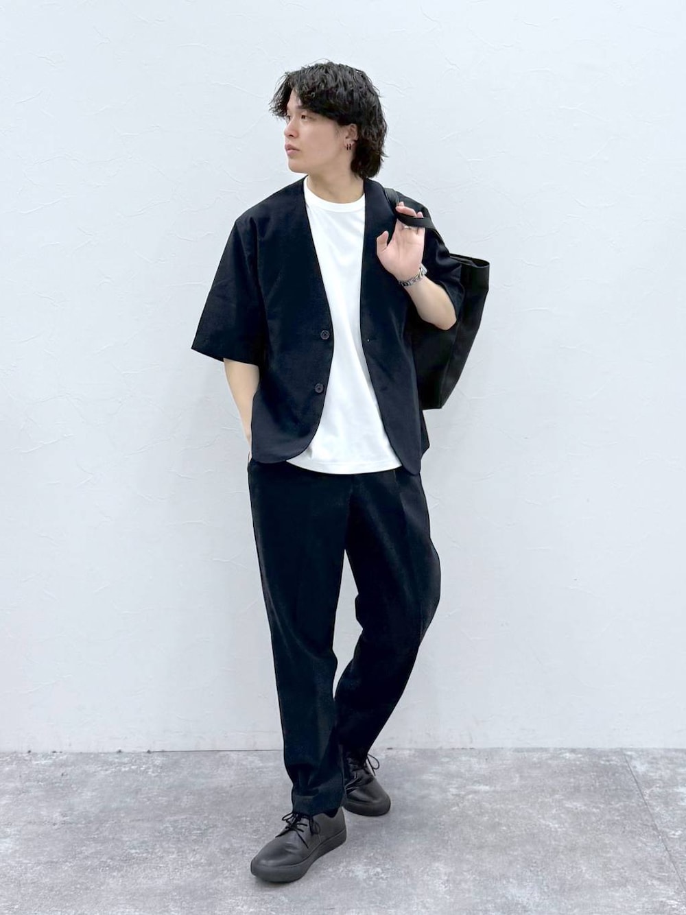 ブラック系のトートバッグ、ホワイト系のTシャツ/カットソー、ブルー系のノーカラージャケットを着用したメンズの春コーディネートの1枚目の写真