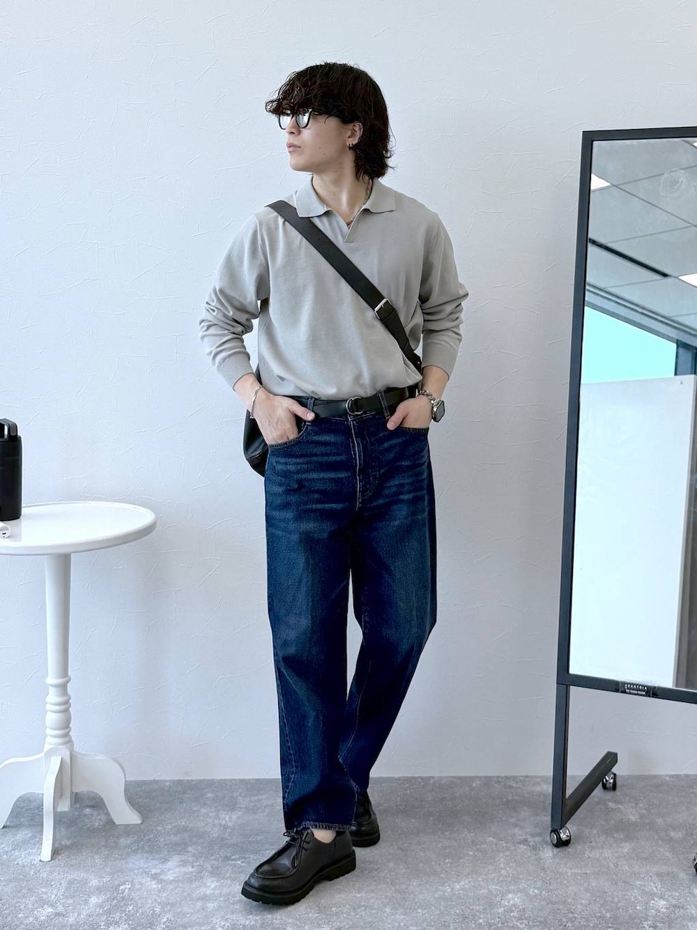 ブルー系のデニムパンツ、ベージュ系のニット/セーター、ブラック系のその他シューズを着用したメンズの秋コーディネートの1枚目の写真