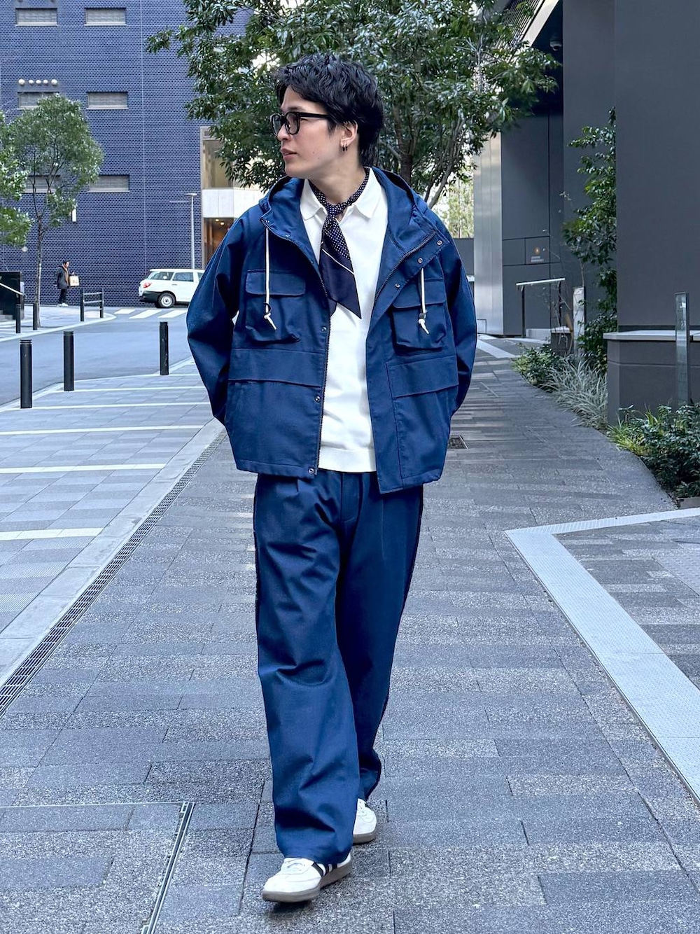 ブルー系のデニムパンツ、ブルー系のマウンテンパーカー、ブラック系のサングラスを着用したメンズの冬コーディネートの1枚目の写真