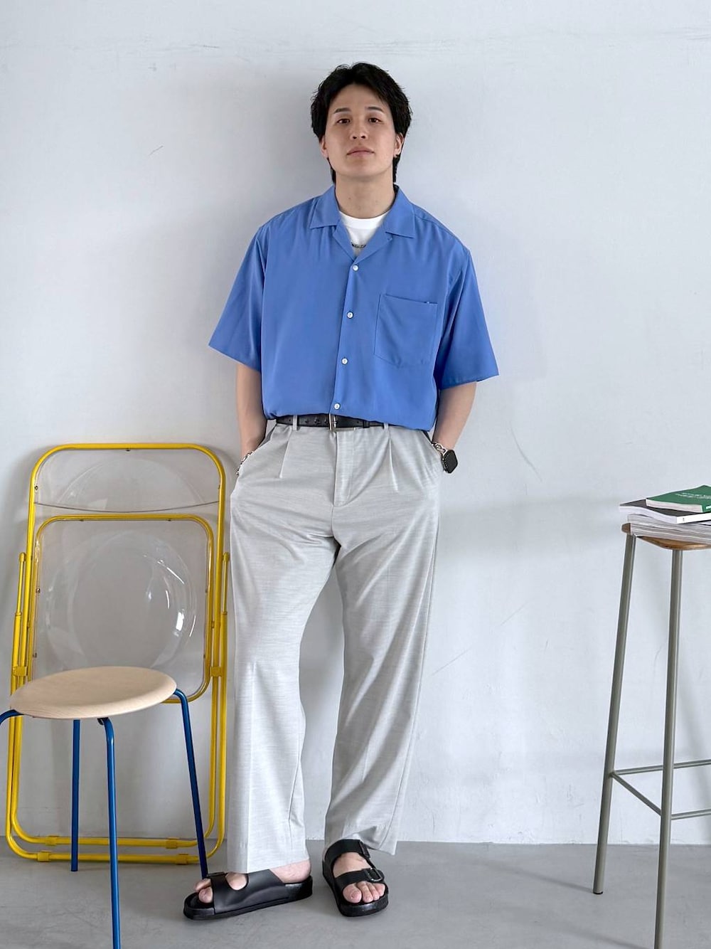 ホワイト系のスラックス、ホワイト系のTシャツ/カットソー、ブラック系のサンダルを着用したメンズの夏コーディネートの1枚目の写真