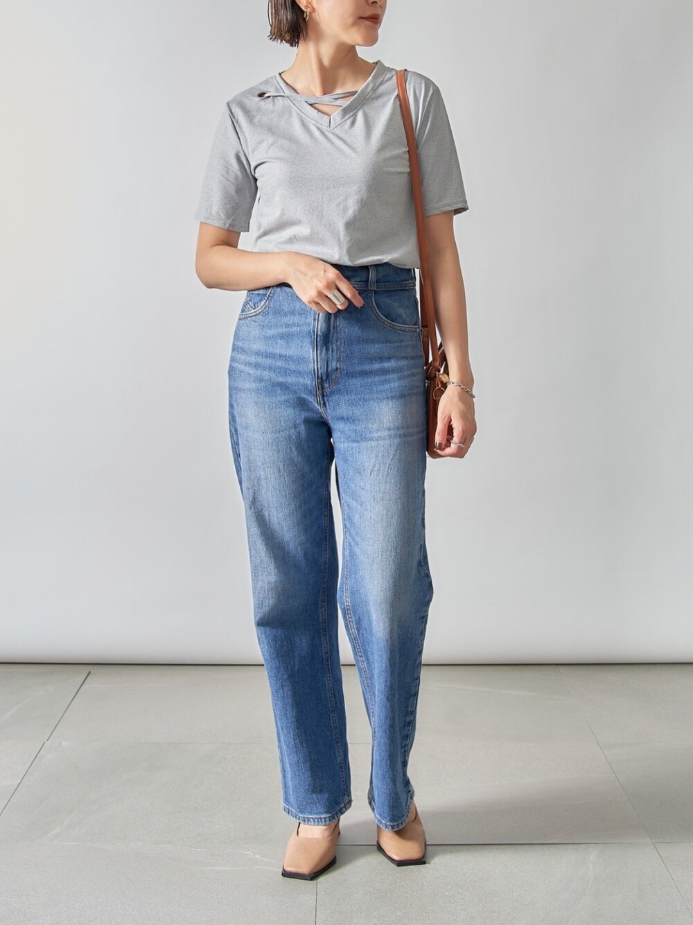 ベージュ系のパンプス、ブラウン系のショルダーバッグ、グレー系のTシャツ/カットソーを着用したレディースの夏コーディネートの1枚目の写真