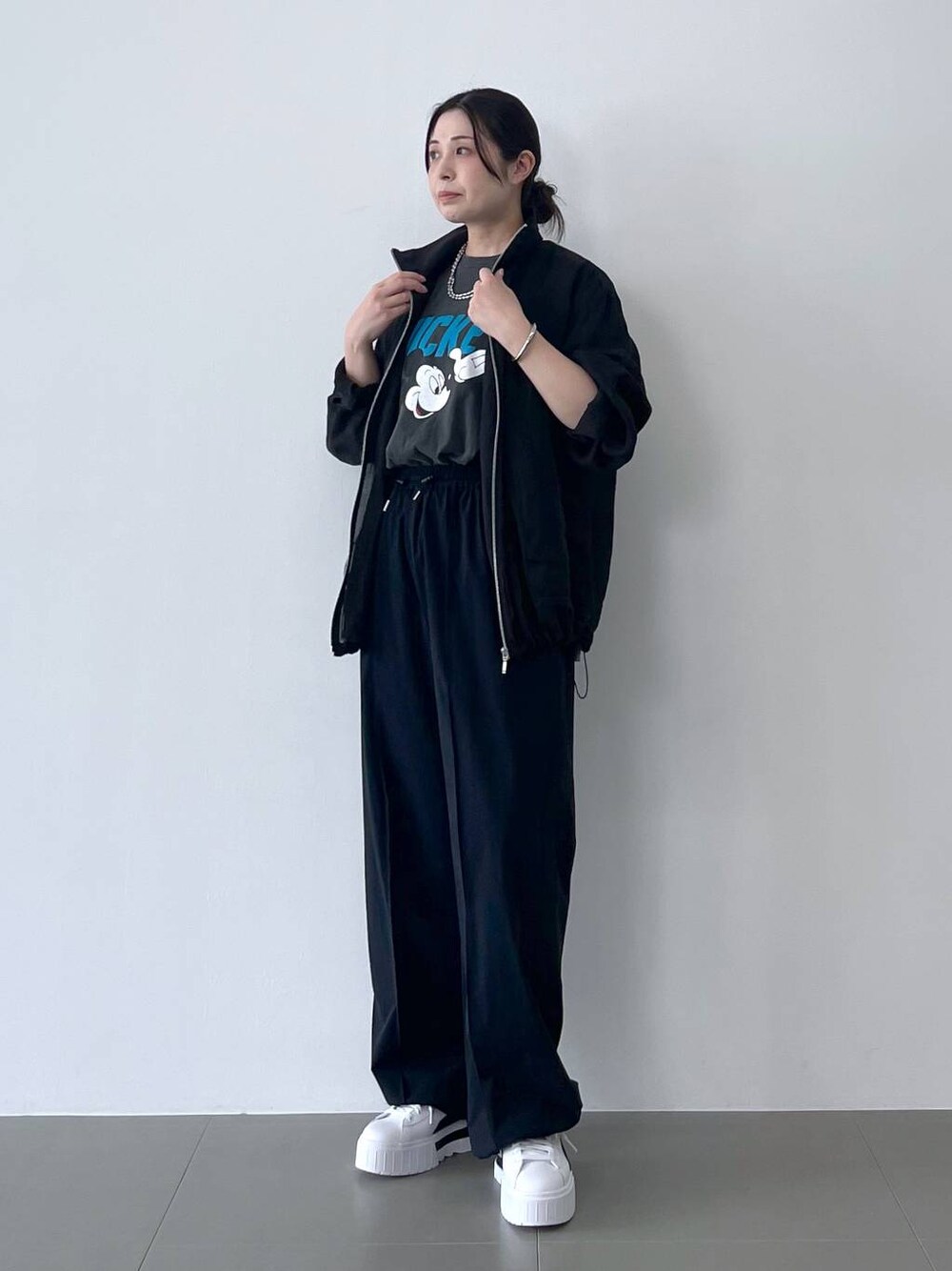 ブラック系のブルゾン、ブラック系のその他パンツ、グレー系のTシャツ/カットソーを着用したレディースの春コーディネートの1枚目の写真