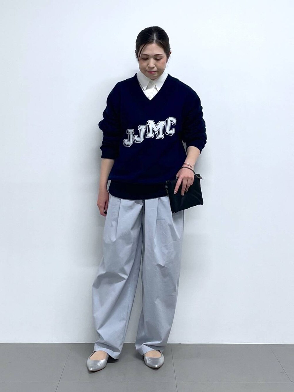 ブラック系のショルダーバッグ、ブルー系のニット/セーター、ホワイト系のシャツ/ブラウスを着用したレディースの冬コーディネートの1枚目の写真