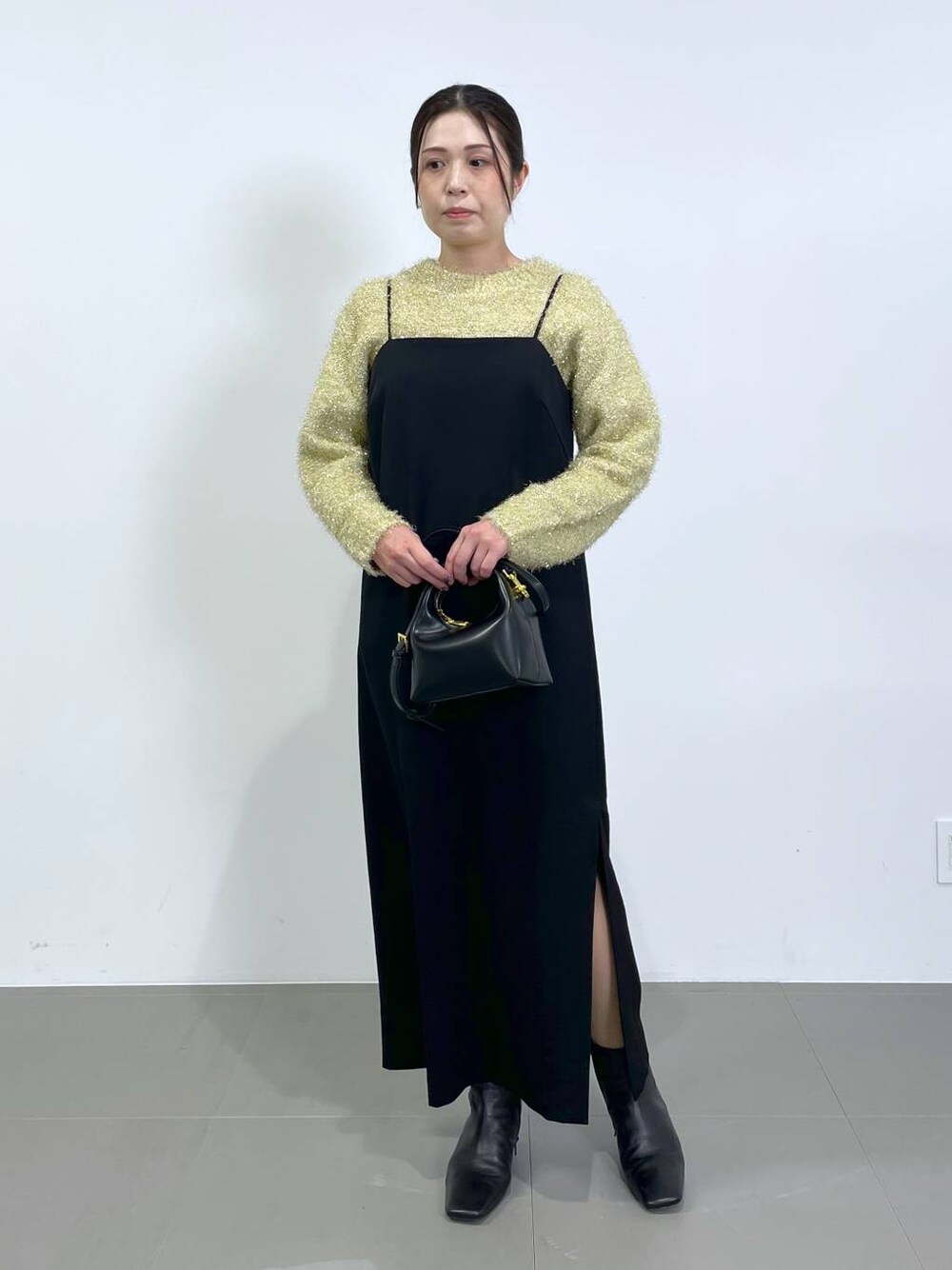 ブラウン系のニット/セーター、ブラック系のワンピースを着用したレディースの冬コーディネートの1枚目の写真