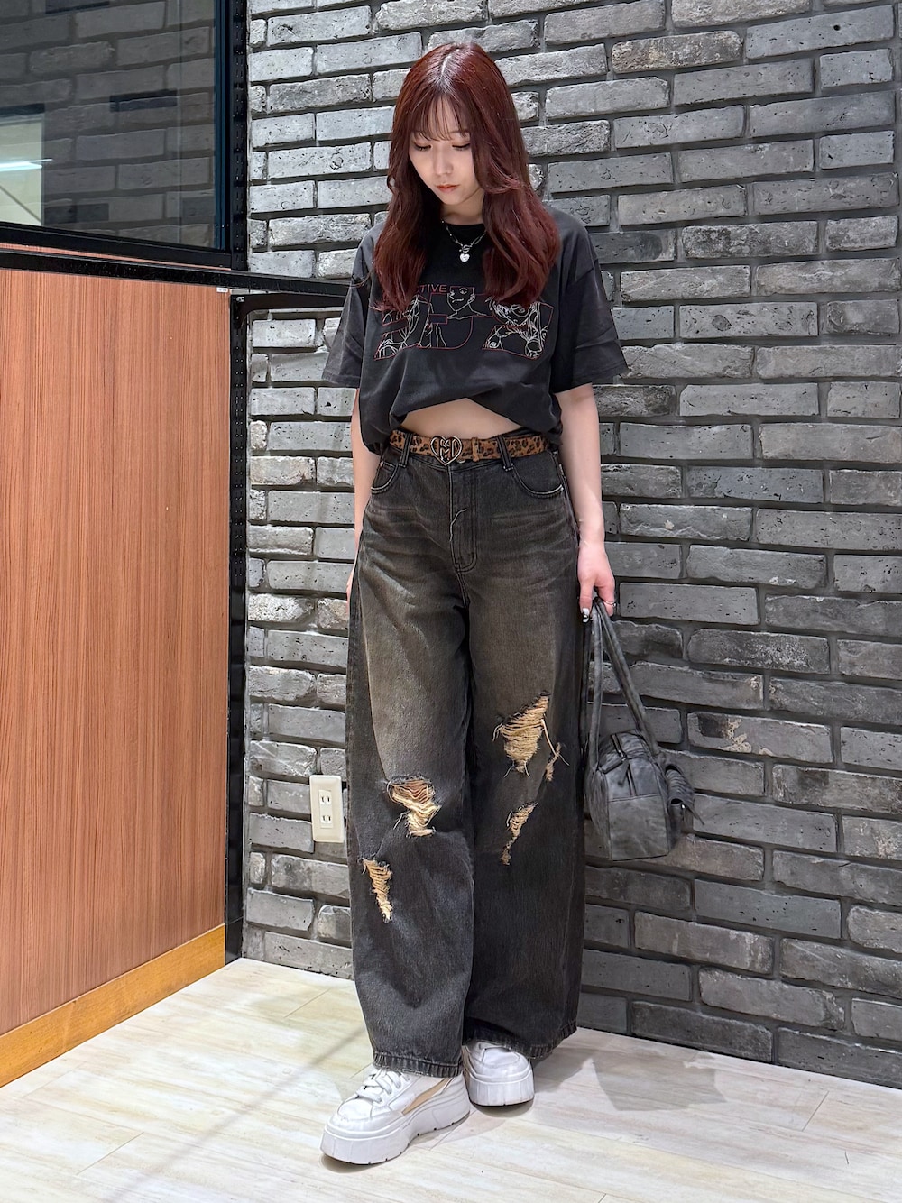 ブラック系のデニムパンツ、ブラック系のボストンバッグを着用したレディースの春コーディネートの1枚目の写真