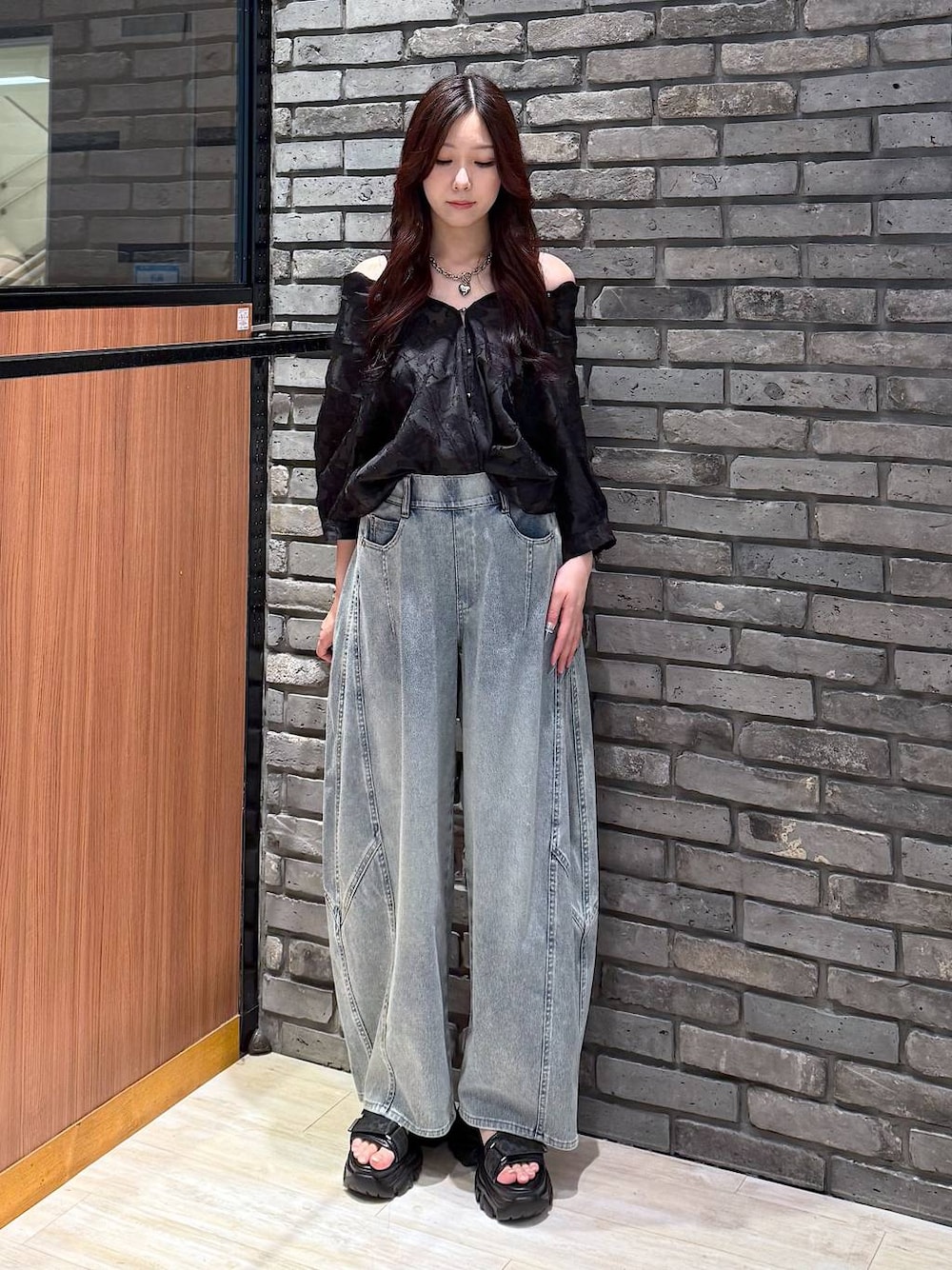 ブルー系のデニムパンツ、ブラック系のサンダル、ブラック系のシャツ/ブラウスを着用したレディースの夏コーディネートの1枚目の写真