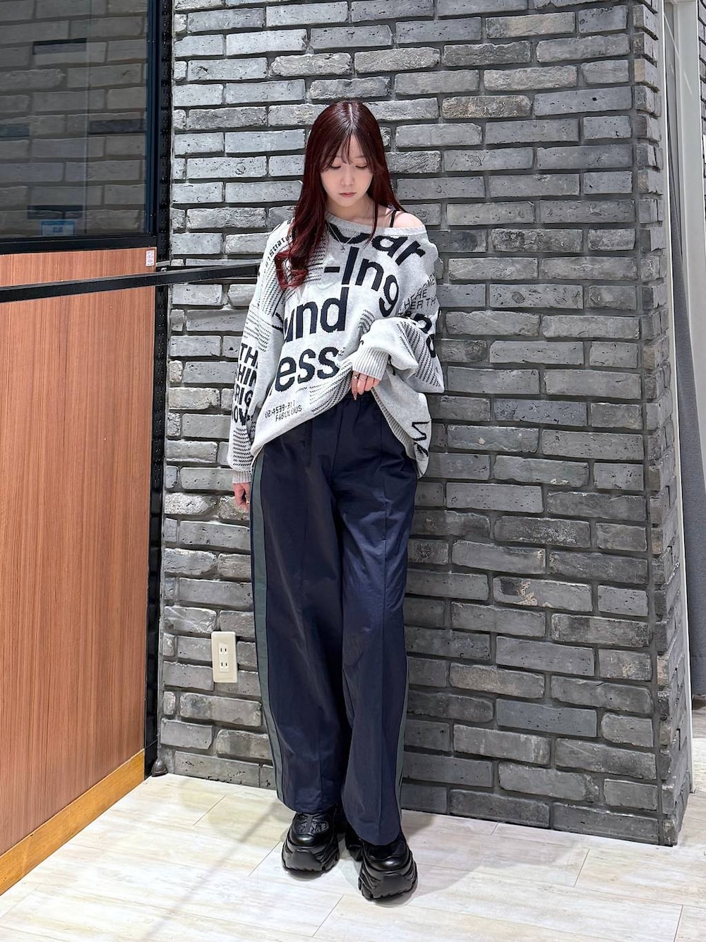 ブラック系のスニーカー、ブルー系のスウェットパンツ、グレー系のニット/セーターを着用したレディースの冬コーディネートの1枚目の写真