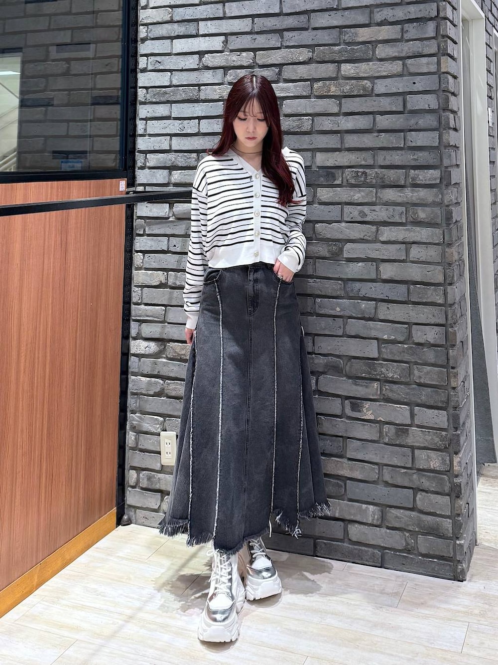 ホワイト系のブーツ、ブラック系のデニムスカート、ホワイト系のTシャツ/カットソーを着用したレディースの冬コーディネートの1枚目の写真