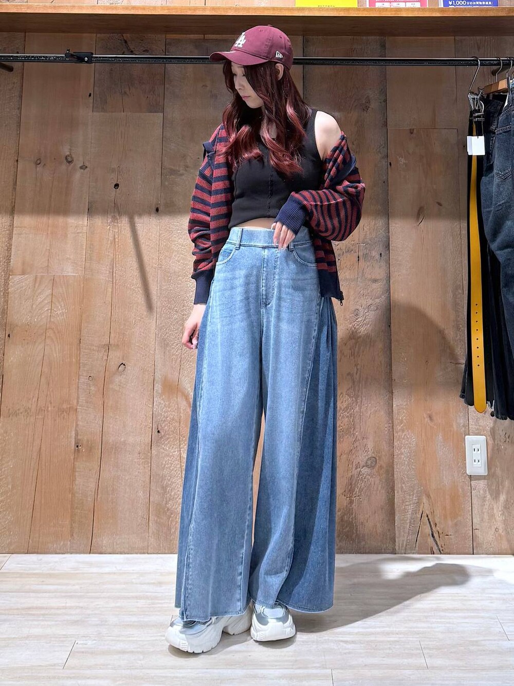 ブルー系のデニムパンツ、シルバー系のスニーカー、ブラック系のタンクトップを着用したレディースの夏コーディネートの1枚目の写真