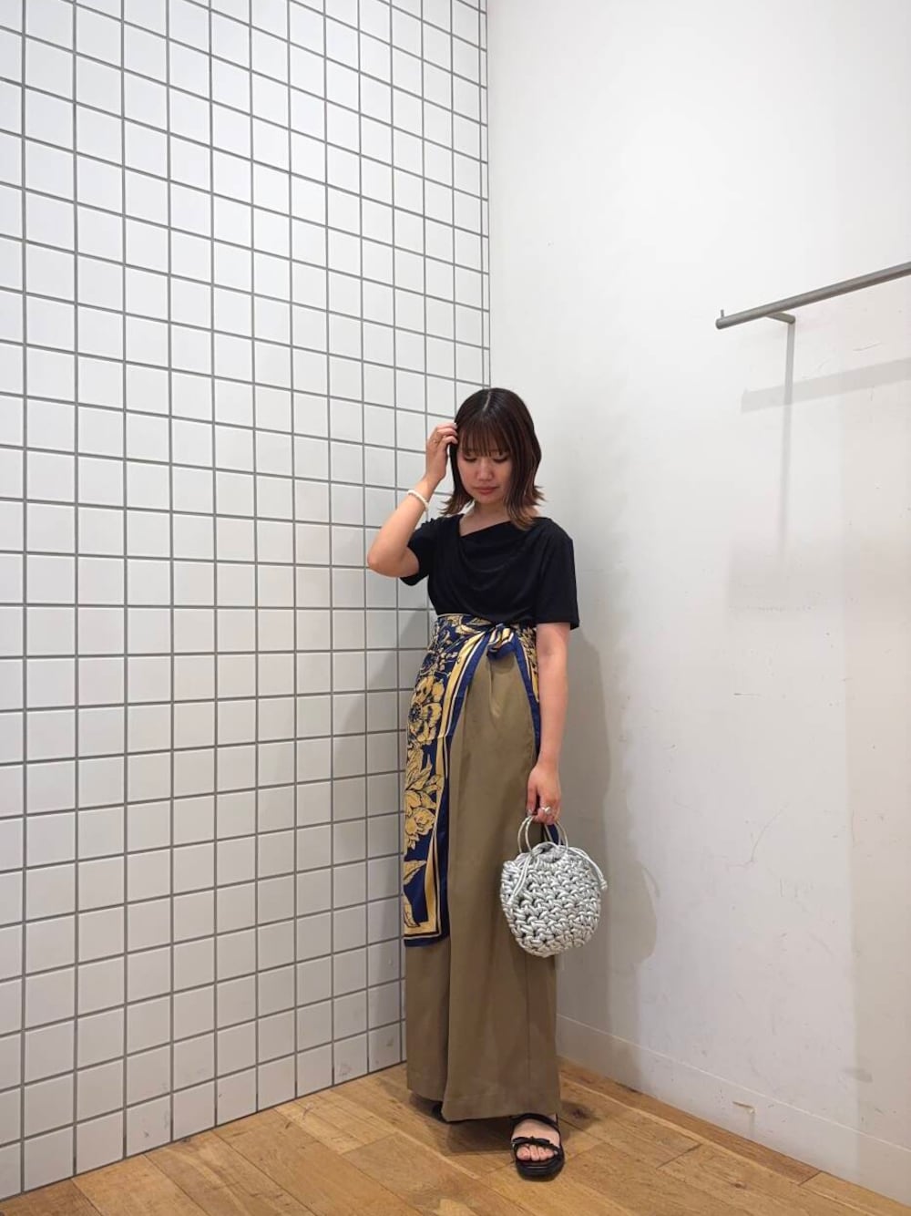 シルバー系のハンドバッグ、ベージュ系のその他パンツ、ブラック系のTシャツ/カットソーを着用したレディースの夏コーディネートの1枚目の写真