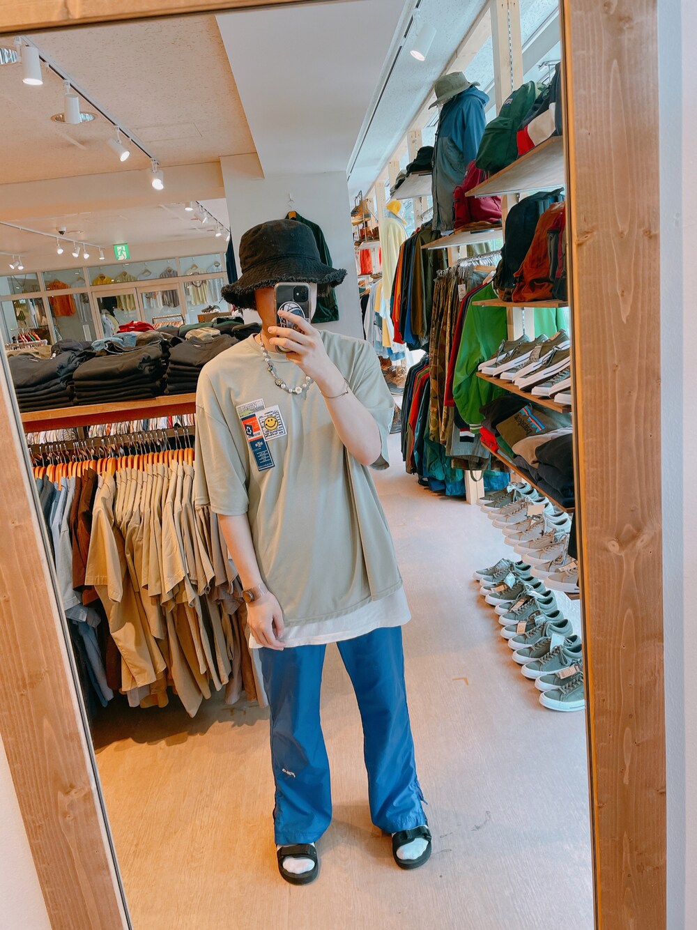 グリーン系のTシャツ/カットソー、ブルー系のその他パンツ、ブラック系のサンダルを着用したメンズの春コーディネートの1枚目の写真