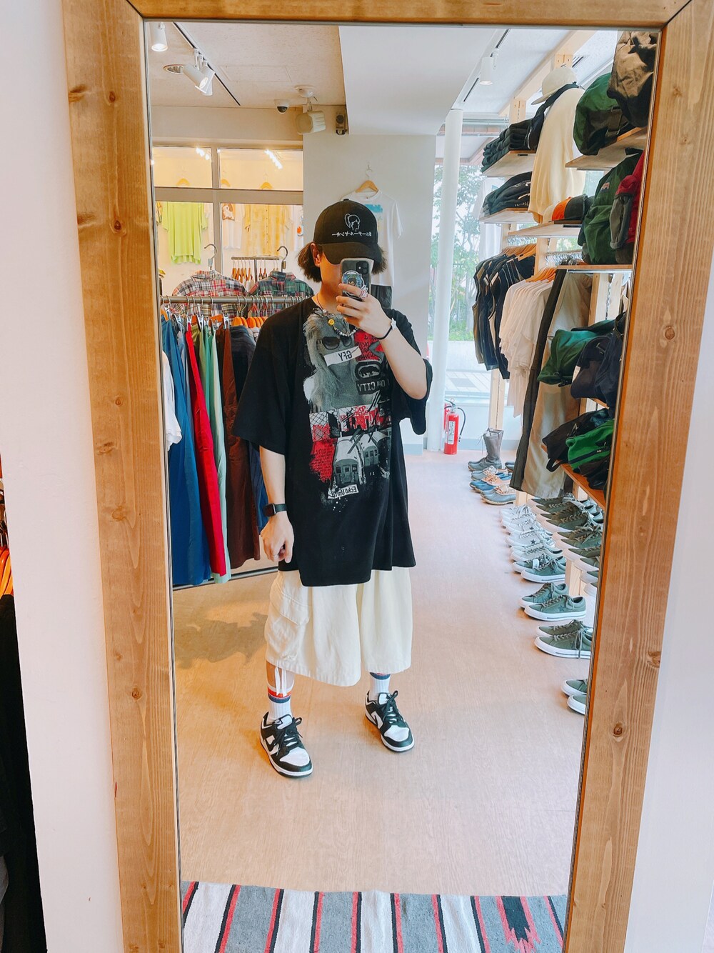 ブラック系のTシャツ/カットソー、ホワイト系のスニーカー、ホワイト系のカーゴパンツを着用したメンズの夏コーディネートの1枚目の写真