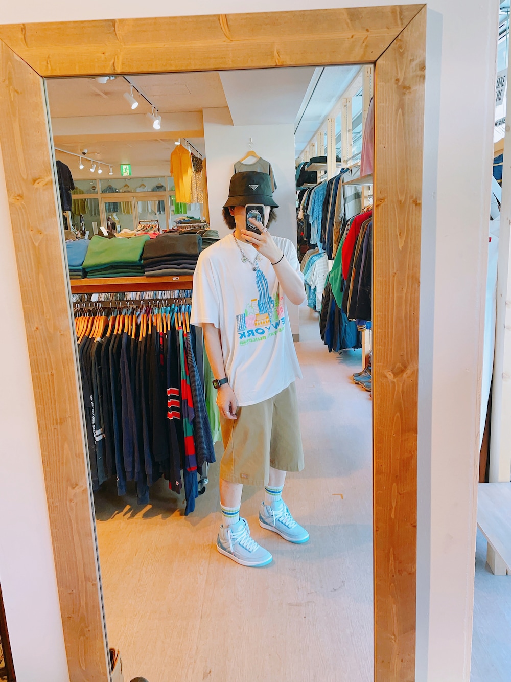 ホワイト系のTシャツ/カットソー、ベージュ系のチノパンツ、ブルー系のスニーカーを着用したメンズの夏コーディネートの1枚目の写真