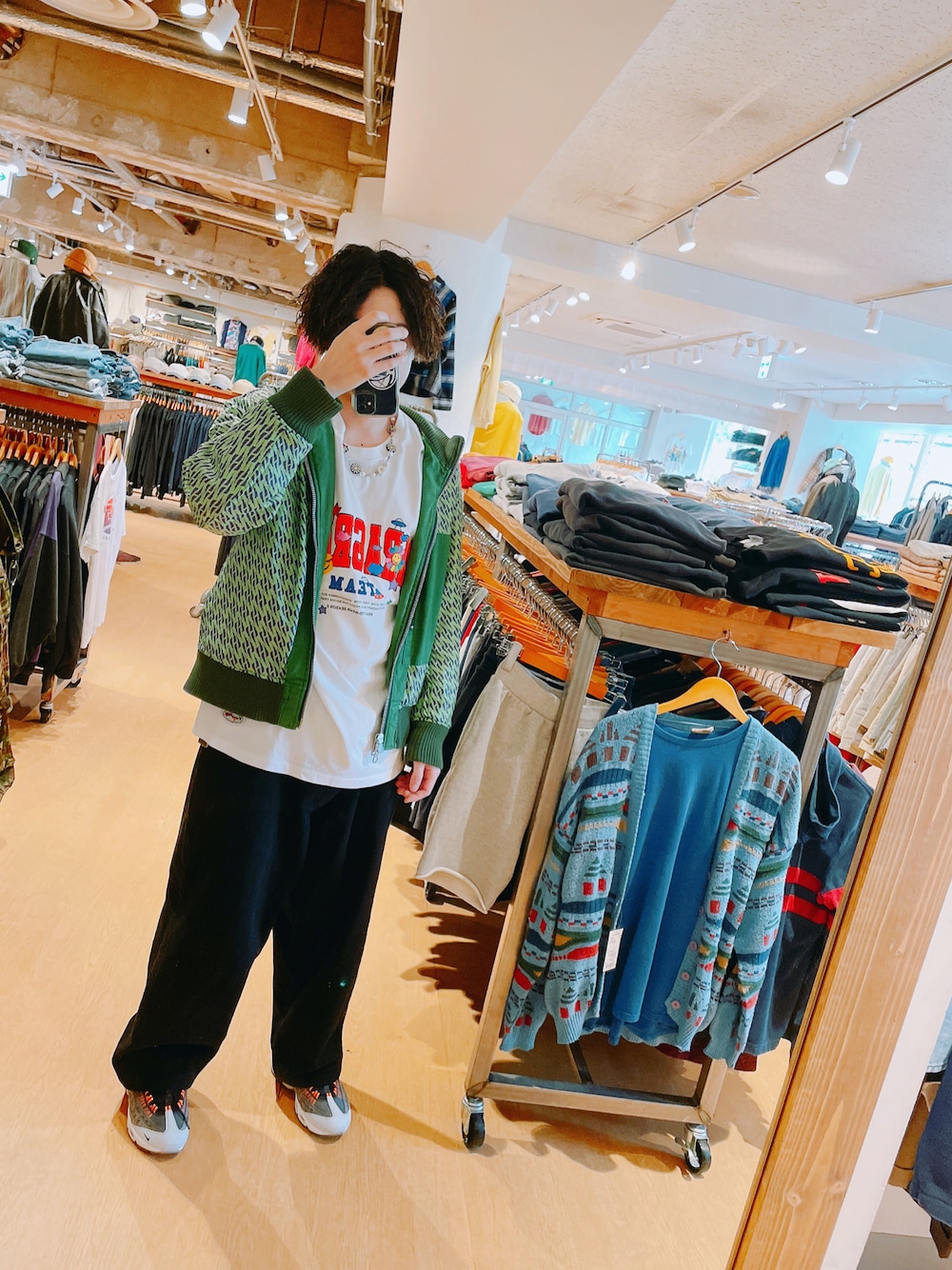 グリーン系のナイロンジャケット、ホワイト系のTシャツ/カットソー、ブラック系のデニムパンツを着用したメンズの春コーディネートの1枚目の写真
