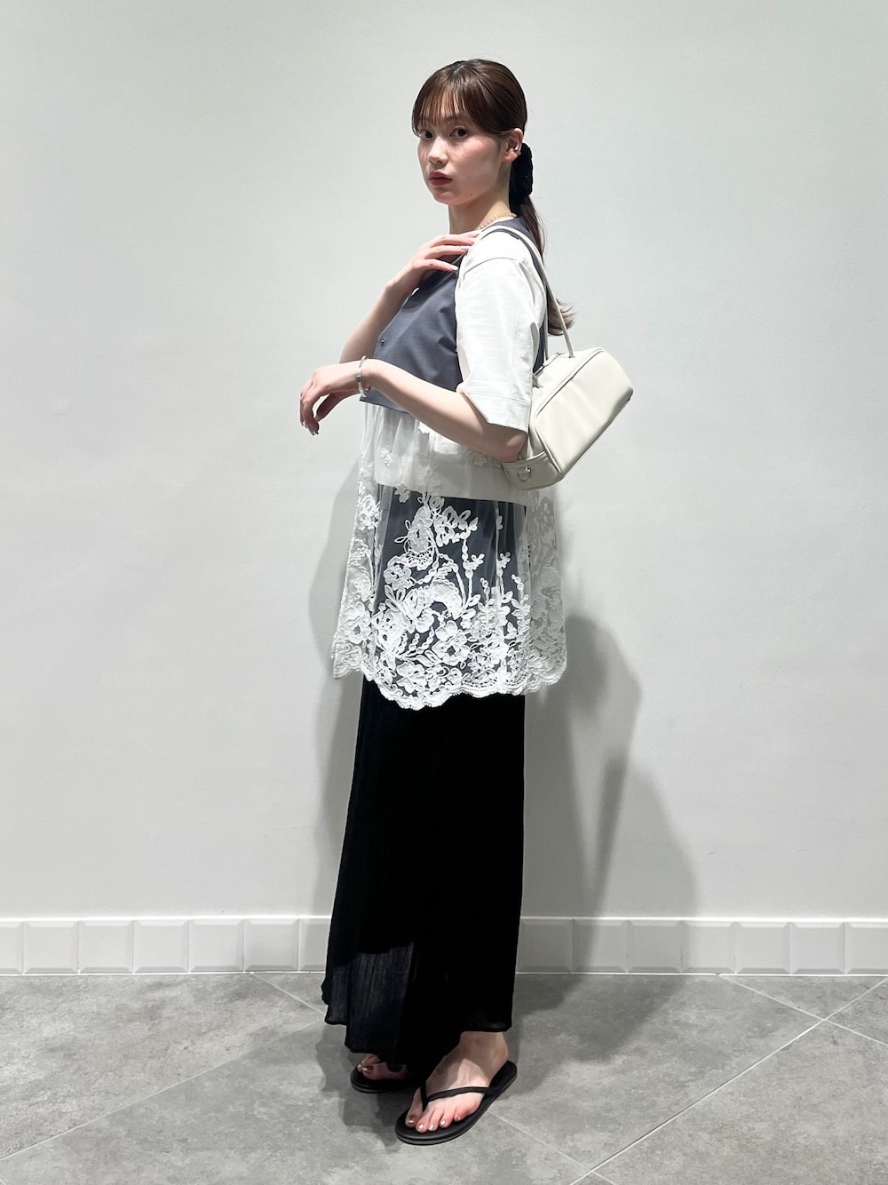 グレー系のベスト、ブラック系のスカート、ホワイト系のTシャツ/カットソーを着用したレディースの夏コーディネートの1枚目の写真