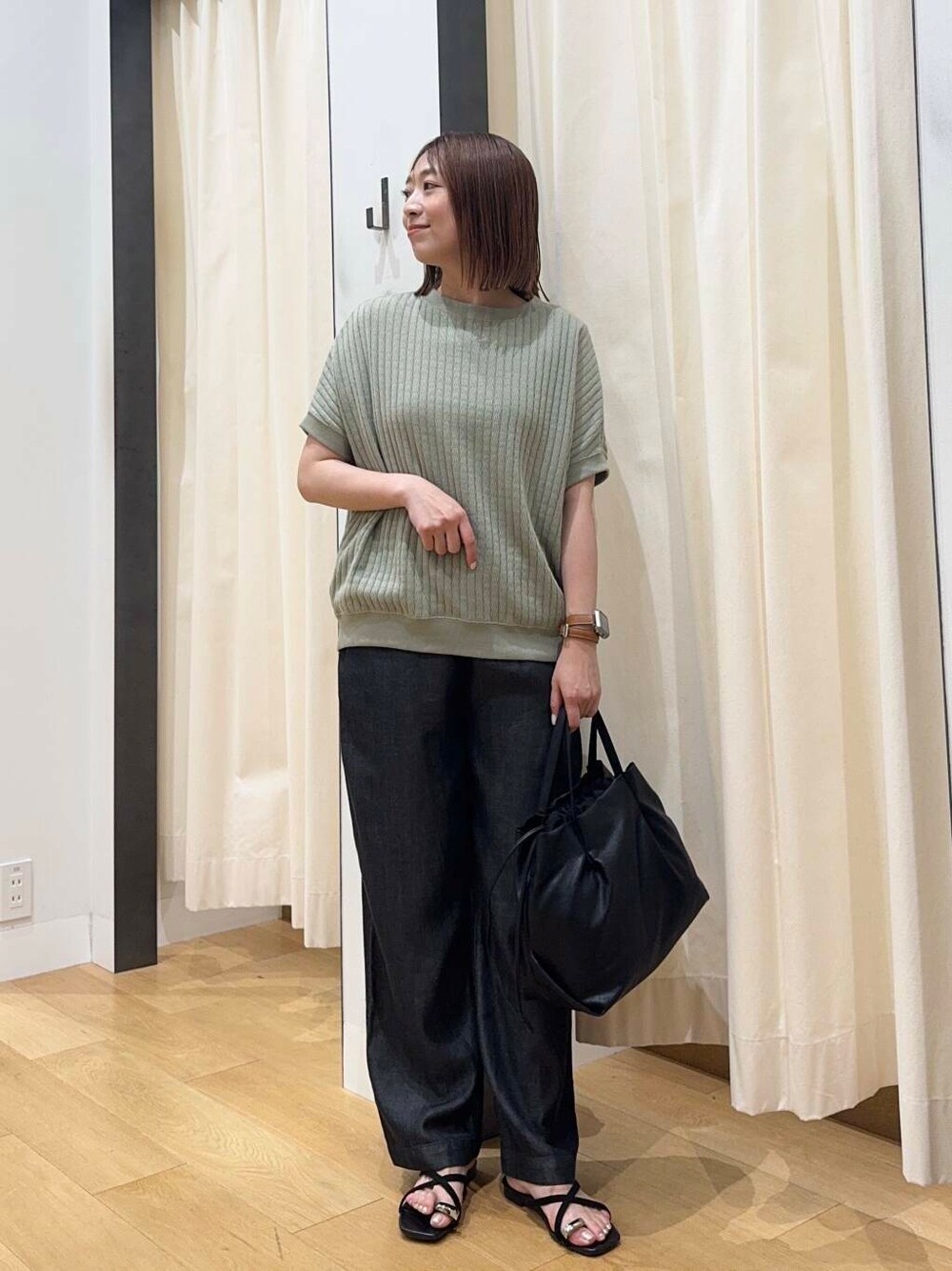 ブラック系のショルダーバッグ、ブラック系のデニムパンツ、グリーン系のTシャツ/カットソーを着用したレディースの夏コーディネートの1枚目の写真