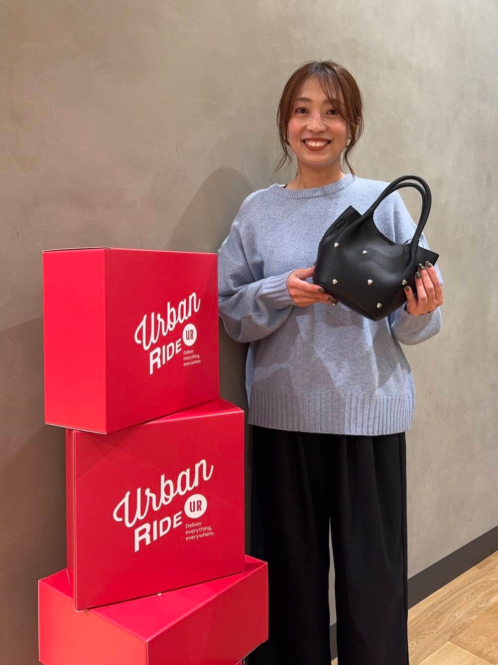 ブルー系のニット/セーター、ブラック系のショルダーバッグを着用したレディースの冬コーディネートの1枚目の写真