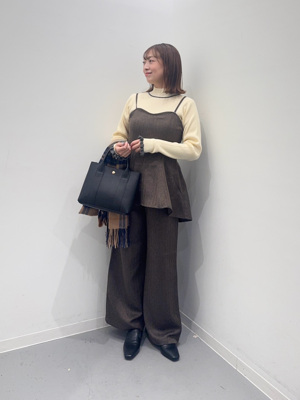 ブラウン系のサロペット/オーバーオール、ブラック系のトートバッグ、ブラック系のローファーを着用したレディースの冬コーディネートの1枚目の写真