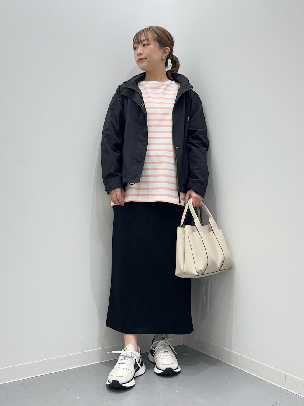 ピンク系のTシャツ/カットソー、ブラック系のマウンテンパーカー、ブラック系のスカートを着用したレディースの春コーディネートの1枚目の写真