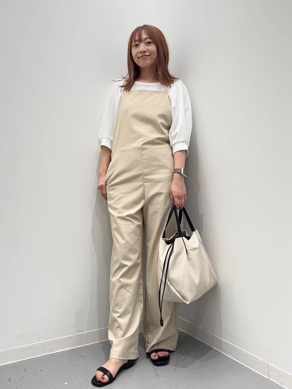 ブラック系のサンダル、ホワイト系のショルダーバッグ、ホワイト系のTシャツ/カットソーを着用したレディースの夏コーディネートの1枚目の写真