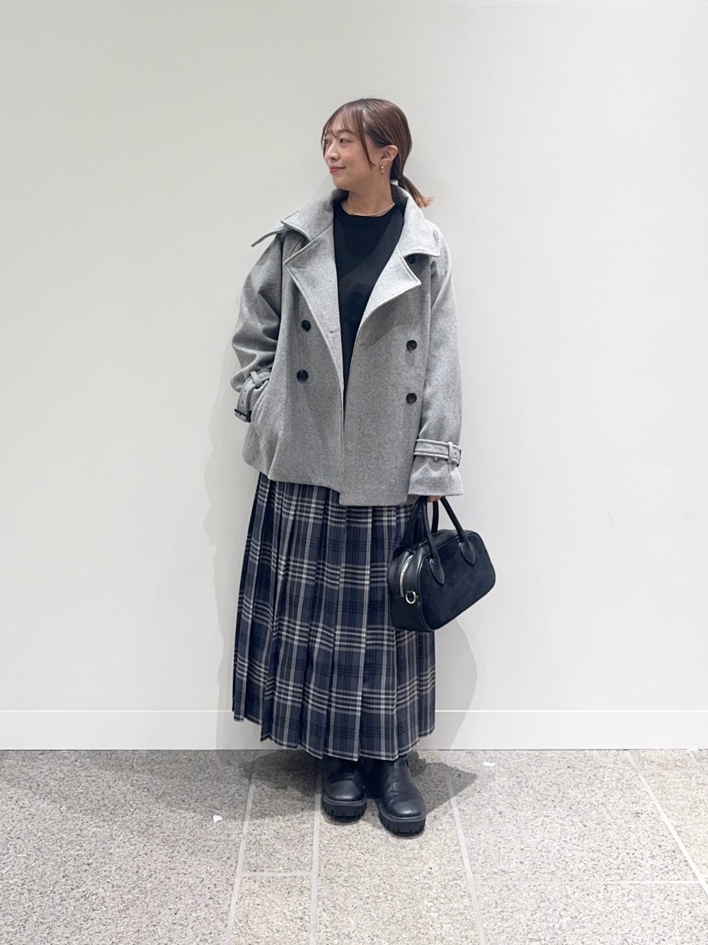 グレー系のその他アウター、ブラック系のニット/セーター、グレー系のスカートを着用したレディースの秋コーディネートの1枚目の写真