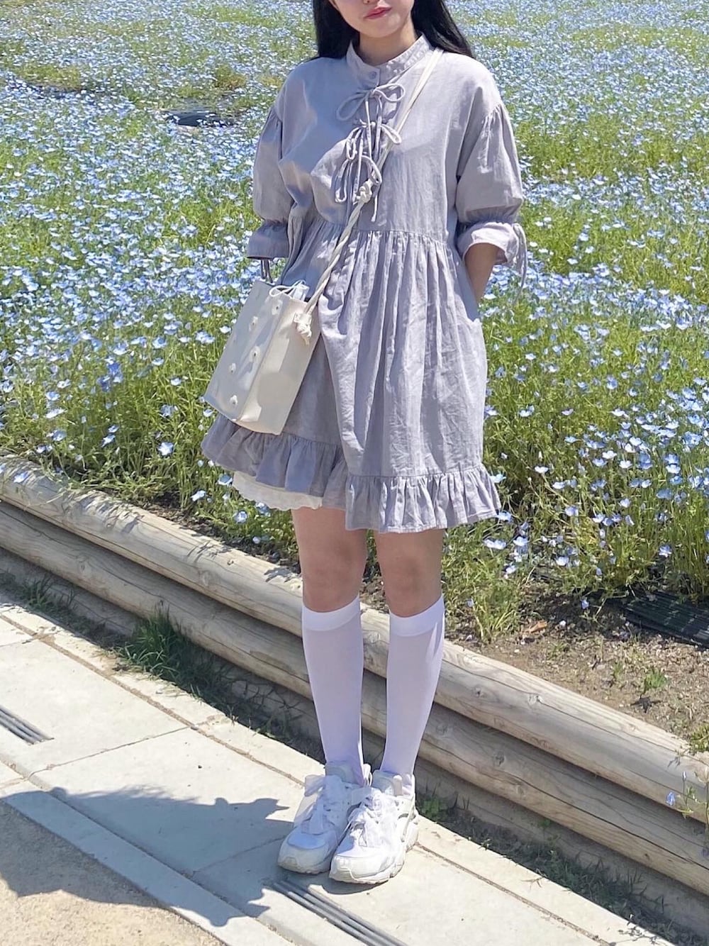 「お出かけコーデ、お花畑、春コーデ、ミニ丈、ミニワンピ、merry jenny、メリージェニー、ハイソックス、ハラチ、NIKE、スニーカーコーデ、スニーカー、散歩、ガーリー」｜「merry jennyのフラワPUーポシェット（ショルダーバッグ、ホワイト系）」を使った、小川さん（レディース・153cm）の春コーディネートの1枚目の写真