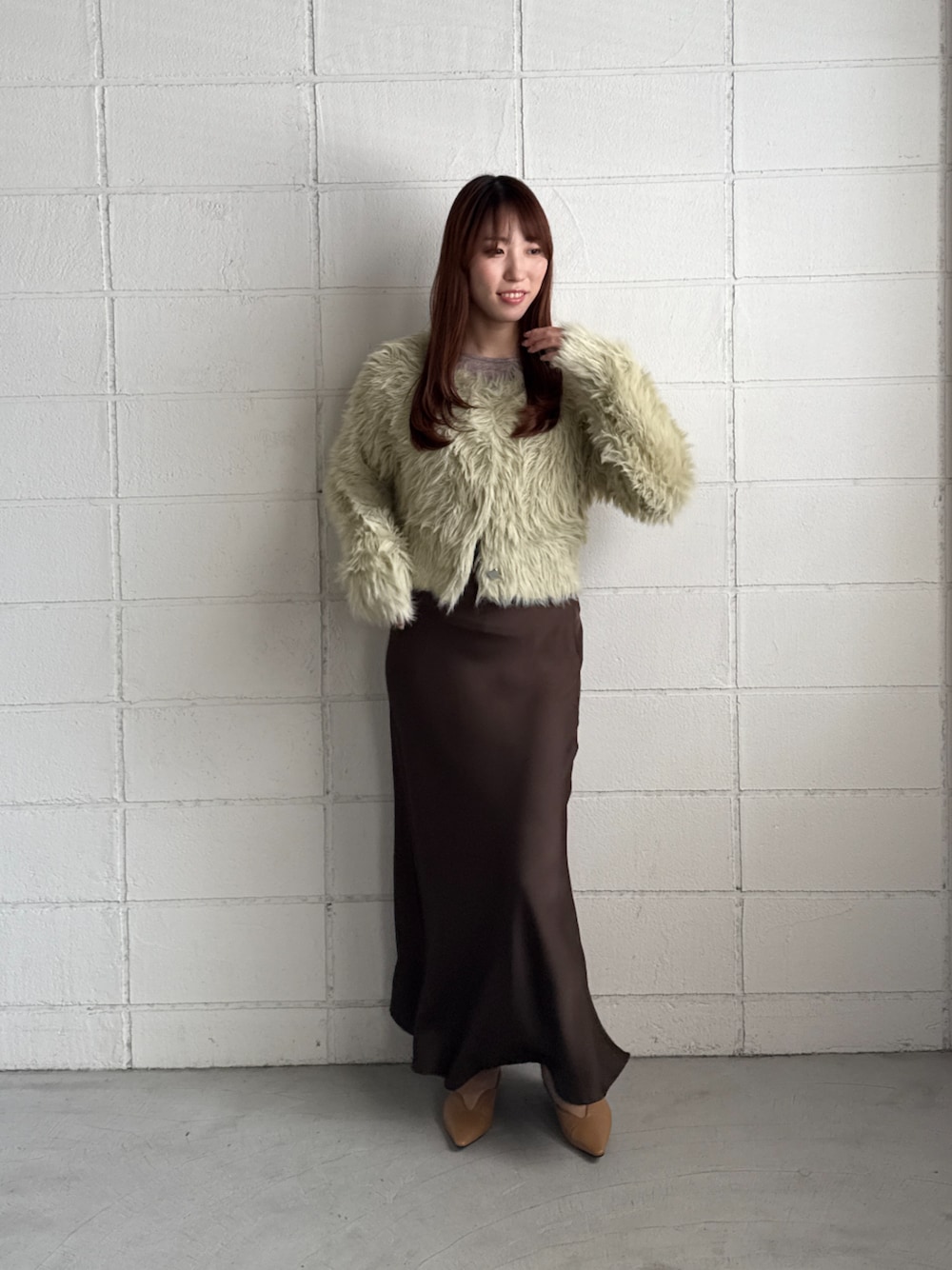 ブラウン系のスカート、グリーン系のカーディガン/ボレロ、ブラウン系のTシャツ/カットソーを着用したレディースの秋コーディネートの1枚目の写真