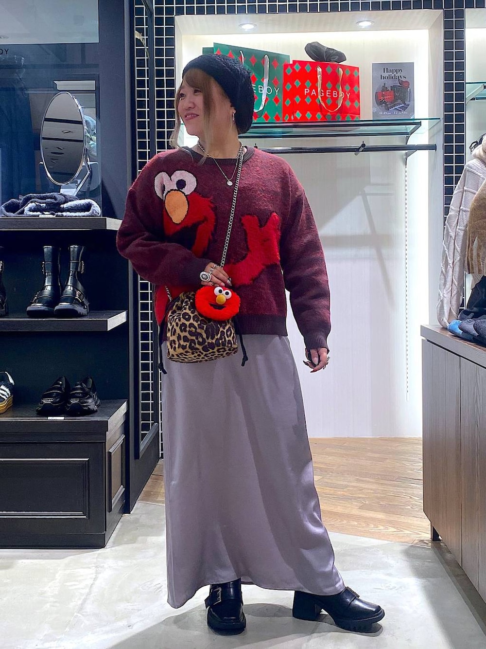 ブラック系のブーツ、その他のハンドバッグ、グレー系のスカートを着用したレディースの冬コーディネートの1枚目の写真