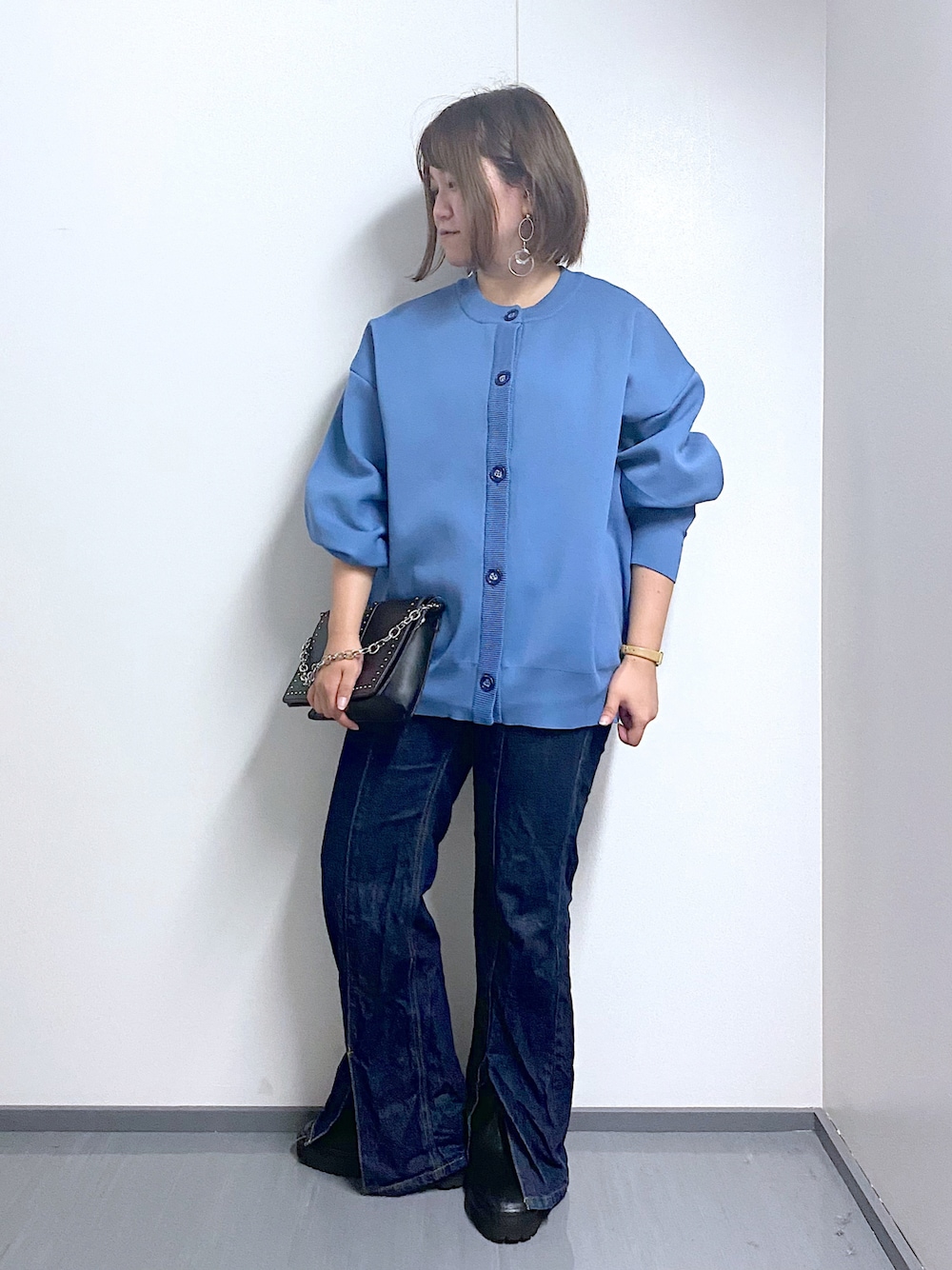ブルー系のカーディガン/ボレロ、ブルー系のデニムパンツ、ブラック系のショルダーバッグを着用したレディースの秋コーディネートの1枚目の写真