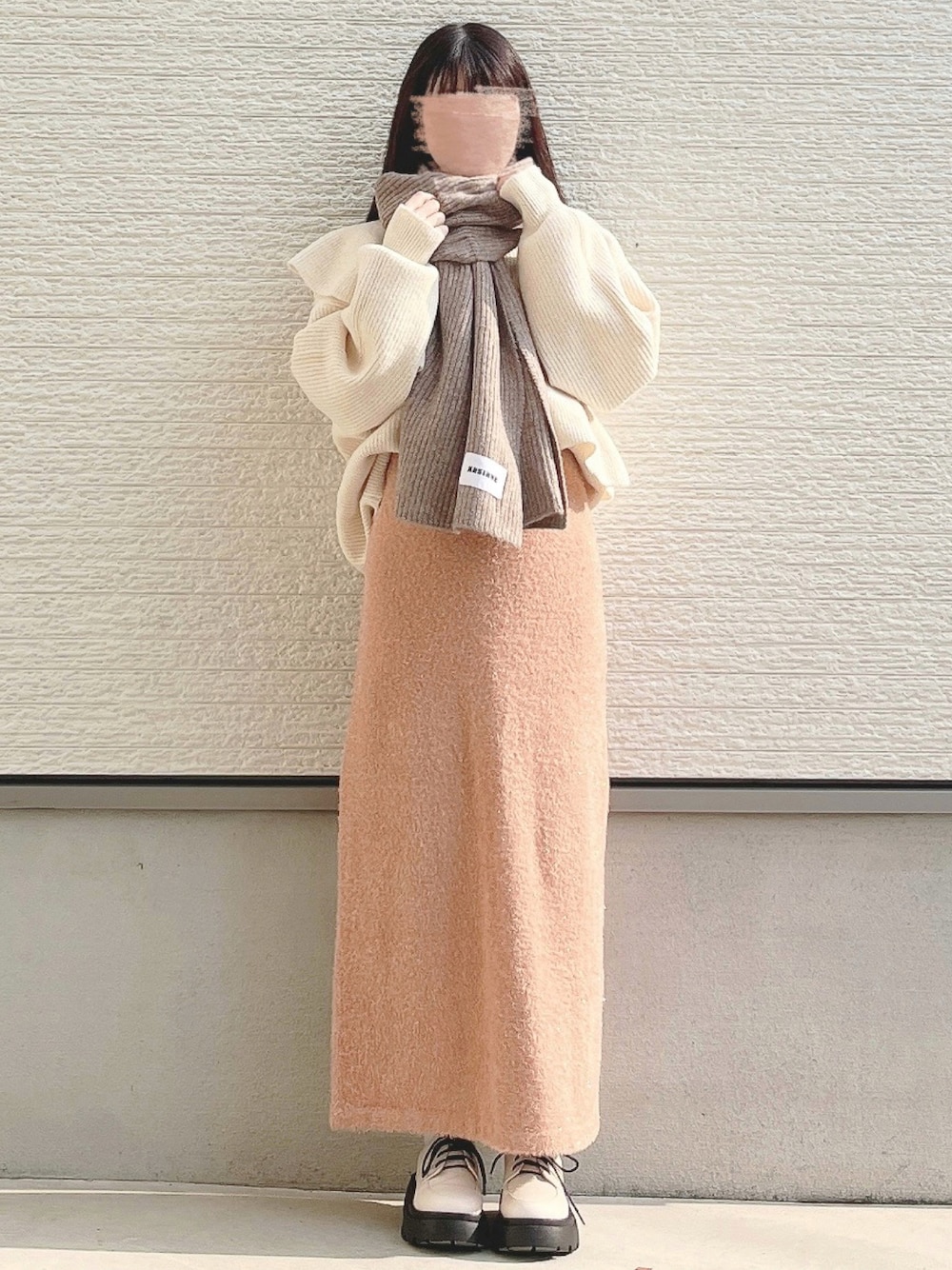 ホワイト系のニット/セーター、ホワイト系のパンプスを着用したレディースの冬コーディネートの1枚目の写真