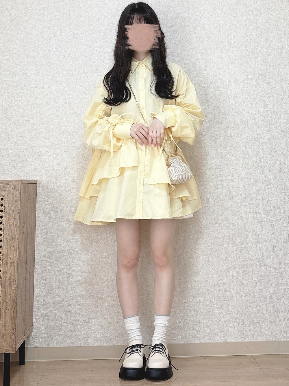 ベージュ系のショルダーバッグ、ホワイト系のパンプスを着用したレディースの冬コーディネートの1枚目の写真