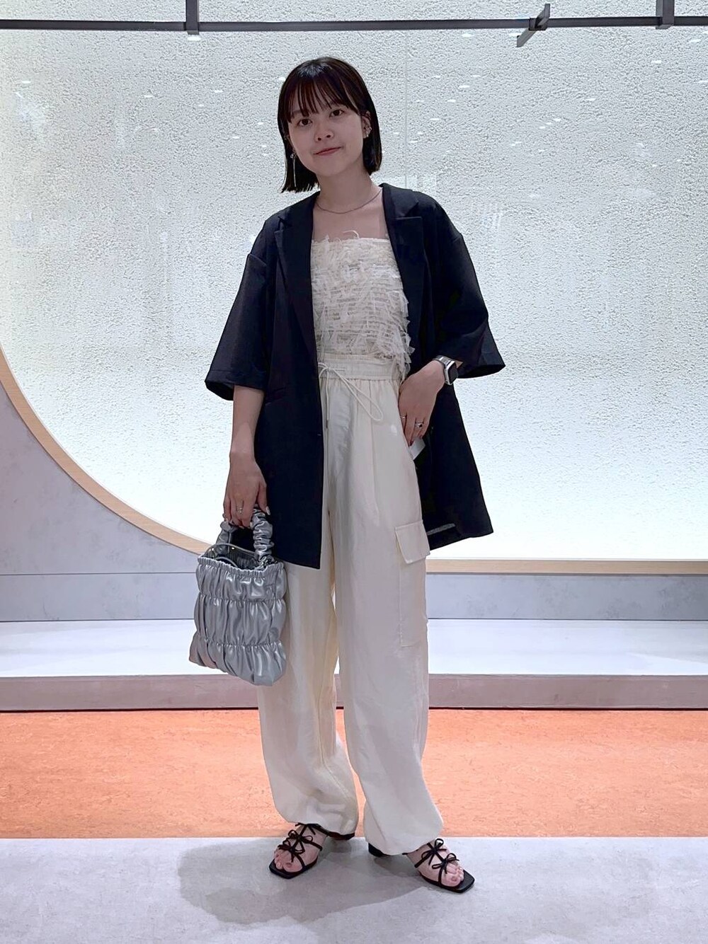 ホワイト系のカーゴパンツ、ブラック系のサンダル、ホワイト系のTシャツ/カットソーを着用したレディースの夏コーディネートの1枚目の写真