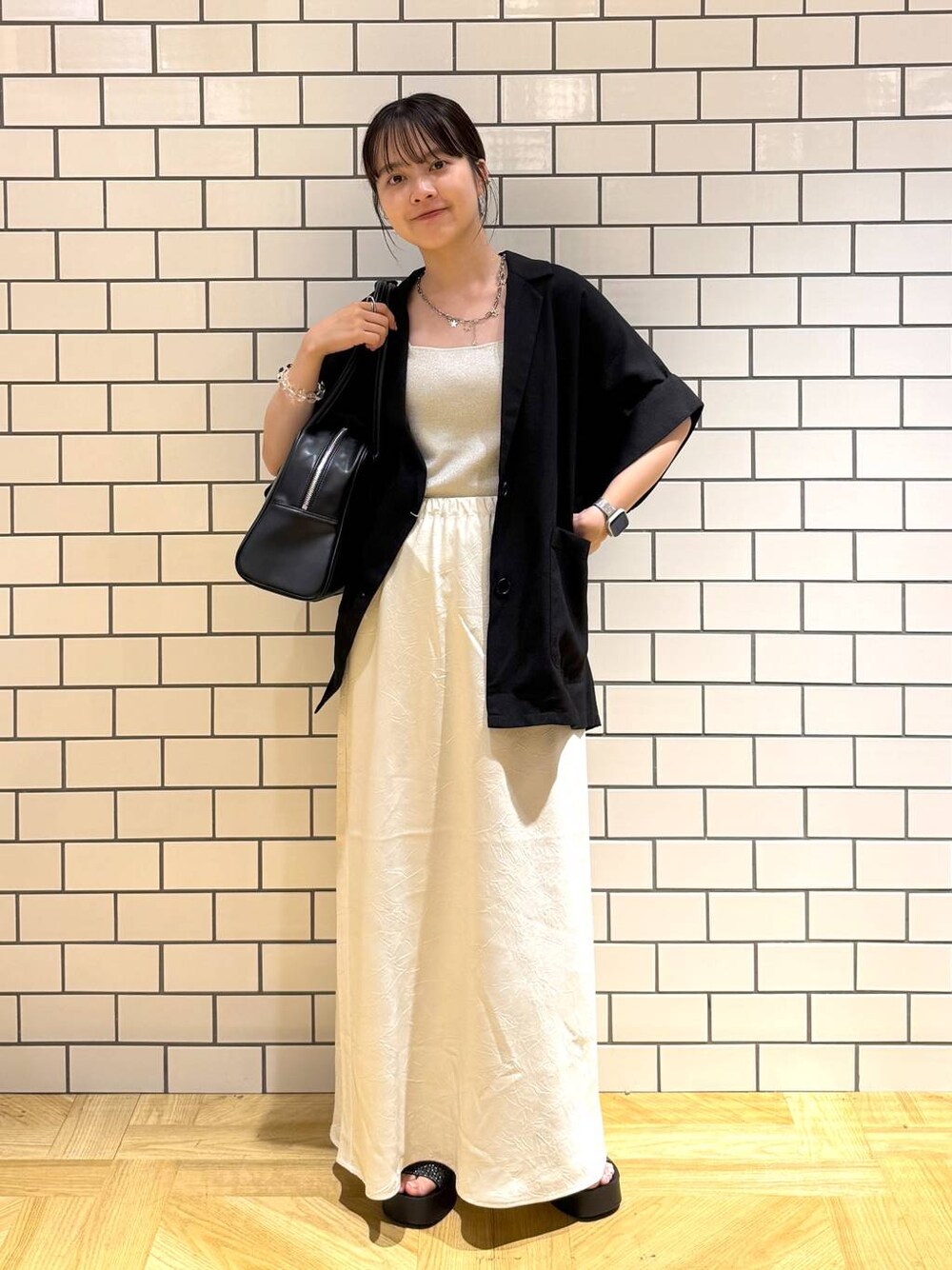 ブラック系のサンダル、ホワイト系のスカート、シルバー系のタンクトップを着用したレディースの夏コーディネートの1枚目の写真