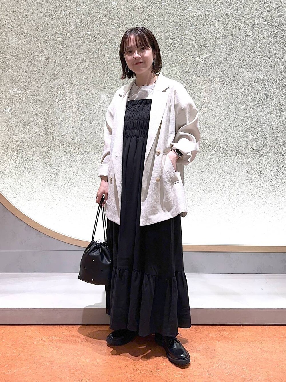 ブラック系のモカシン/デッキシューズ、ブラック系のショルダーバッグ、ホワイト系のテーラードジャケットを着用したレディースの春コーディネートの1枚目の写真