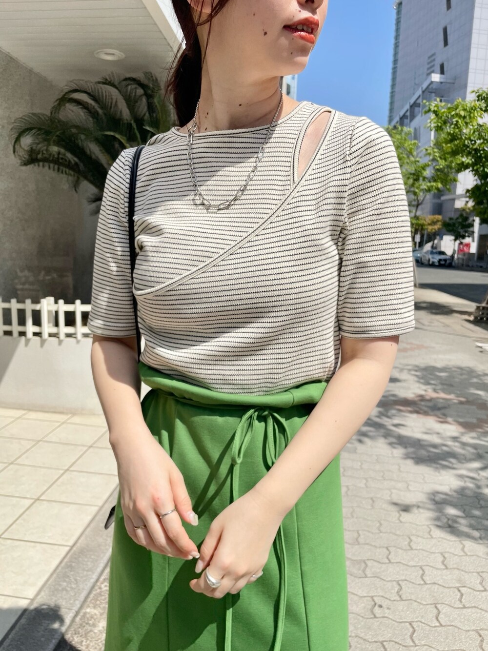 ホワイト系のTシャツ/カットソー、グリーン系のワンピース、ブラック系のサンダルを着用したレディースの春コーディネートの4枚目の写真