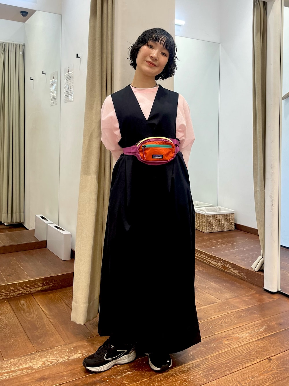 ブラック系のスニーカー、ブルー系のワンピース、ピンク系のニット/セーターを着用したレディースの冬コーディネートの1枚目の写真