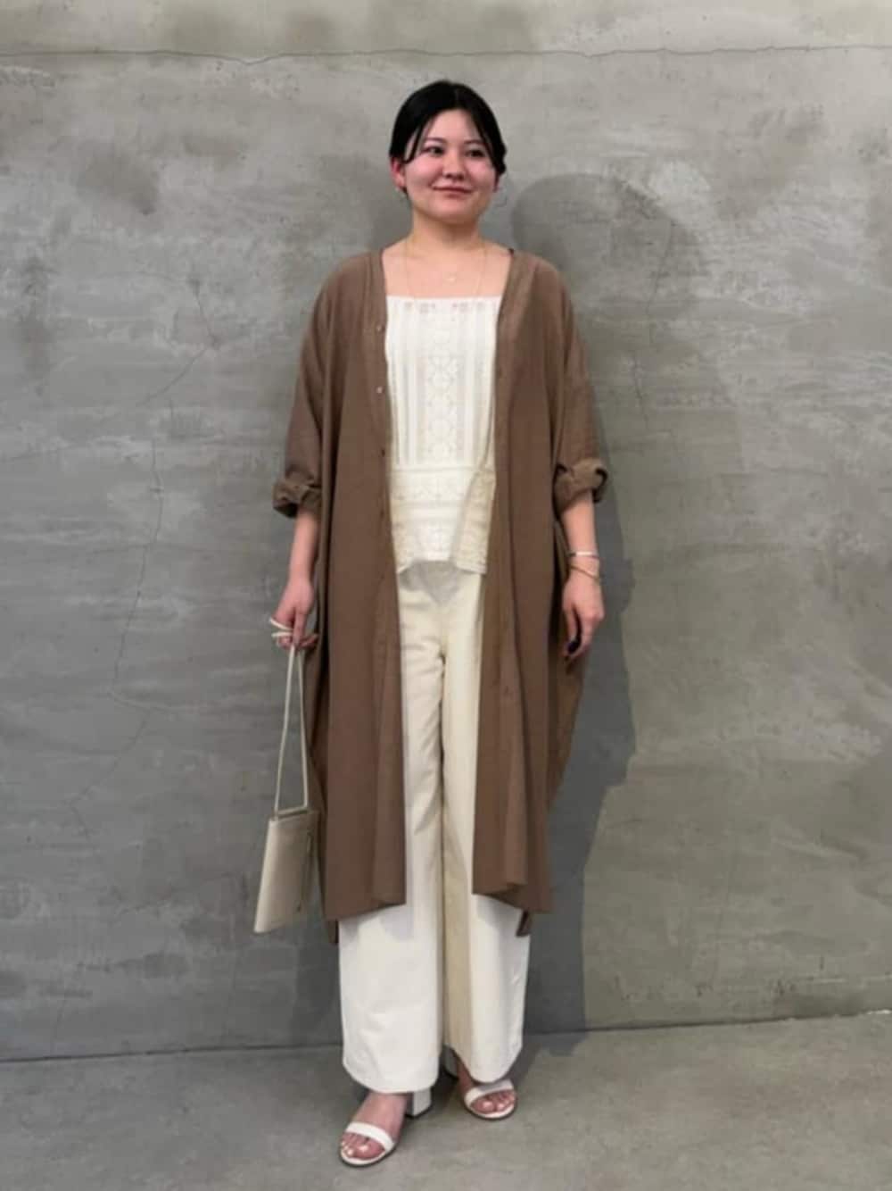 ホワイト系のショルダーバッグ、ホワイト系のシャツ/ブラウス、ベージュ系のワンピースを着用したレディースの冬コーディネートの1枚目の写真