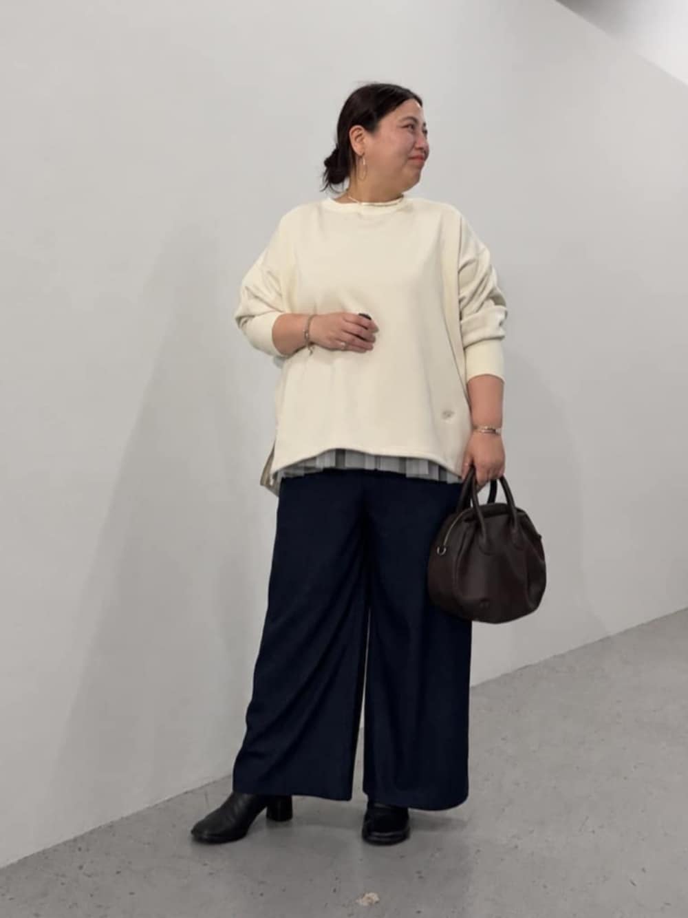ブルー系のその他パンツ、ブラウン系のトートバッグ、ホワイト系のTシャツ/カットソーを着用したレディースの秋コーディネートの1枚目の写真