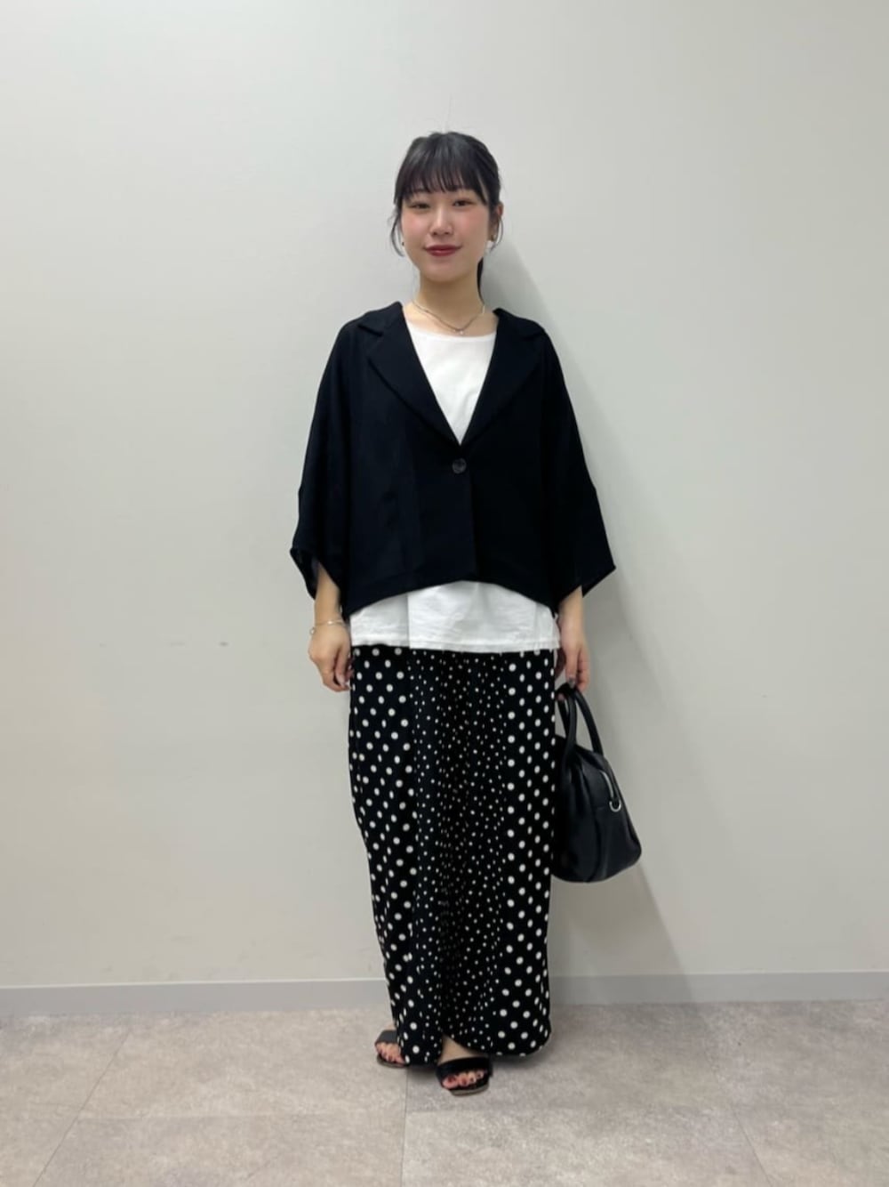 ブラック系のボストンバッグ、ホワイト系のシャツ/ブラウス、ブラック系のその他パンツを着用したレディースの春コーディネートの1枚目の写真