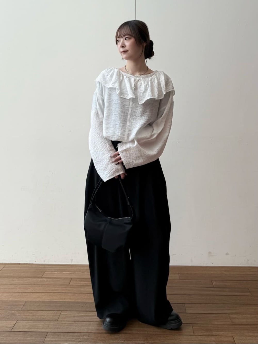 ブラック系のショルダーバッグ、ブラック系のその他パンツ、ホワイト系のシャツ/ブラウスを着用したレディースの冬コーディネートの1枚目の写真